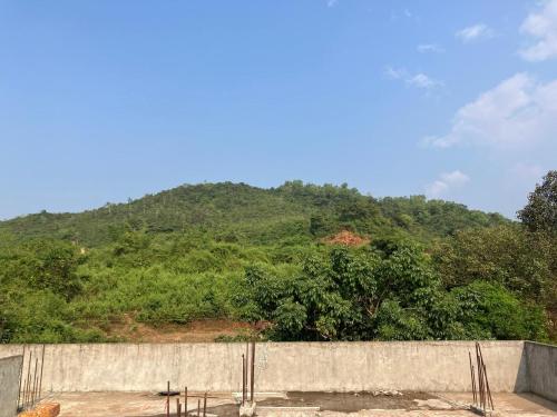 a concrete wall with a mountain in the background at ASA Homestay in Mādangeri