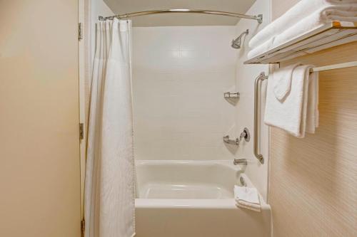 a bathroom with a shower and a white tub at Fairfield Inn and Suites by Marriott Orlando Near Universal Orlando in Orlando