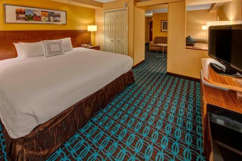 a hotel room with a bed and a flat screen tv at Fairfield Inn and Suites by Marriott Orlando Near Universal Orlando in Orlando