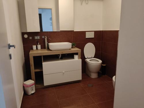 a bathroom with a toilet and a sink and a mirror at Casa CHANEL in Latina