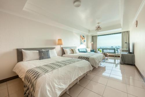 two beds in a hotel room with a view at Artistic Studio in Taichung