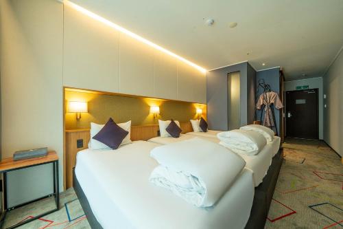 a hotel room with two beds with white pillows at South Vandeco Hotel in Busan