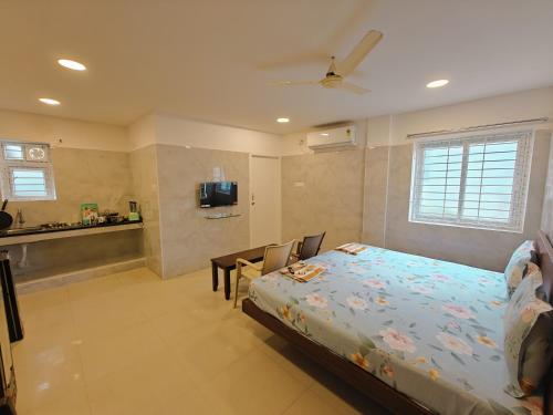 a bedroom with a bed and a table and a tv at HOTEL SAl INN - NEAR AIRPORT in Chennai