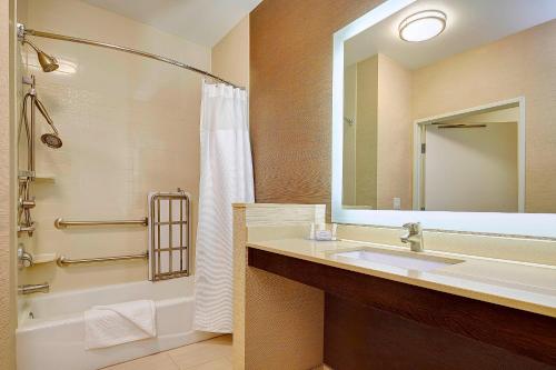 a bathroom with a sink and a tub and a mirror at Fairfield Inn & Suites by Marriott San Diego Carlsbad in Carlsbad
