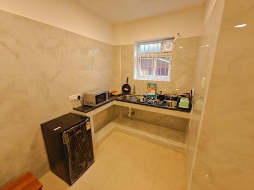 a small kitchen with a sink and a microwave at HOTEL SAl INN - NEAR AIRPORT in Chennai