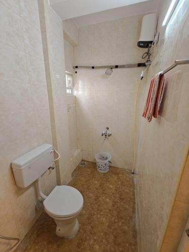 a small bathroom with a toilet and a shower at HOTEL SAl INN - NEAR AIRPORT in Chennai