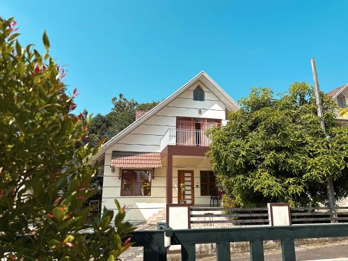 a small white house with a fence in front of it at Chakkantharas Pool Villas in Athirappilly