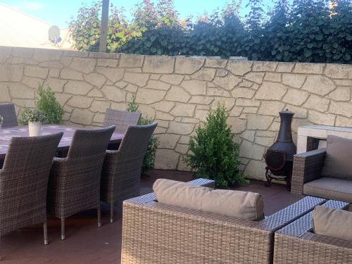 a patio with a table and chairs and a stone wall at Relaxing Getaway Beachfront Access Multi Family Pets Mandurah in Mandurah
