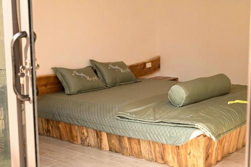 a bed with green pillows on it in a room at Big Homie Garden in Thanh Cao
