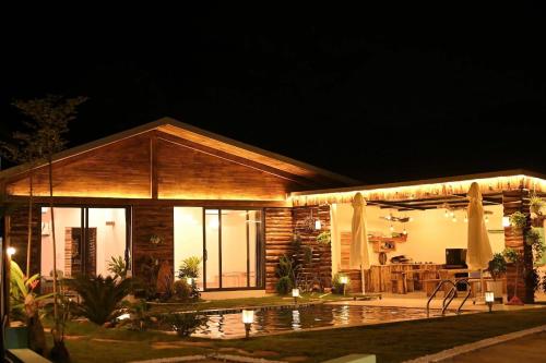 a house with a pool in front of it at night at Big Homie Garden in Thanh Cao