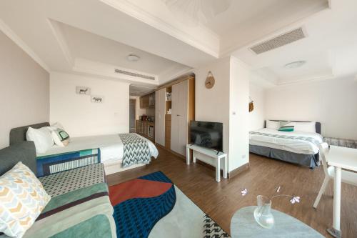 a living room with two beds and a couch at Artistic Studio in Taichung