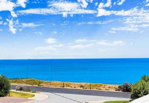 a road with a view of the ocean at Relaxing Getaway Beachfront Access Multi Family Pets Mandurah in Mandurah