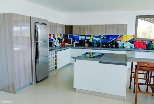 a kitchen with white cabinets and a refrigerator at La Canopée vue sur mer in Nosy Be