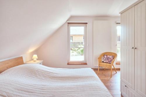 une chambre avec un lit, une chaise et une fenêtre dans l'établissement Finja, à Fuhlendorf