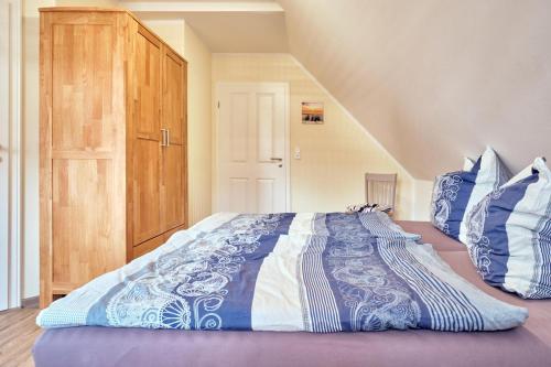 une chambre avec un grand lit avec des draps bleus et blancs dans l'établissement Findus, à Fuhlendorf