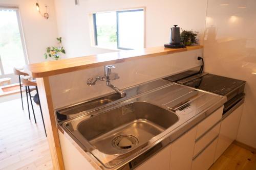 a stainless steel sink in a kitchen with a counter at hostel ALA in Kawaminami