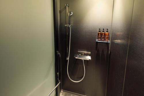 a bathroom with a shower with a glass door at The Royal Park Canvas Fukuoka Nakasu in Fukuoka