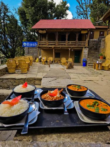a tray with four bowls of food on a table at Basho Mud Huts in Vashisht