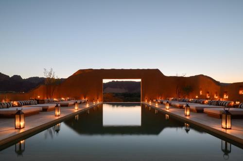 a pool with candles in the water at night at Dar Tantora The House Hotel in AlUla