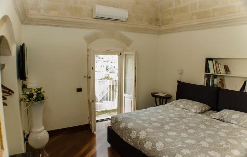 a bedroom with a bed and a door to a balcony at Alla dimora di Chiara Suite and Rooms in Matera