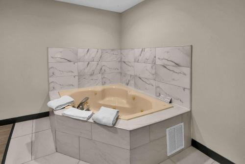 bagno con vasca e pareti in marmo bianco di Baymont by Wyndham Zanesville a Zanesville