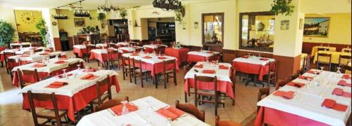 un restaurante con mesas y sillas rojas y blancas en Hotel Stella Bianca, en Scarmagno