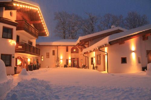 a building covered in snow at night at Hotel Kraftquelle Schlossblick in Angerberg