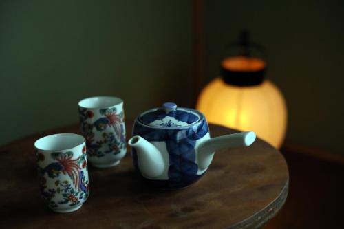 three cups and a blue and white mug on a table at Guesthouse SETOUCHI LIFE in Kure