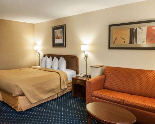 a hotel room with a bed and a couch at Quality Inn & Suites Goshen in Goshen