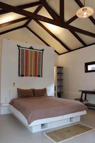 a bedroom with a large bed and a ceiling at OUTSIDE bungalow in Sekongkang