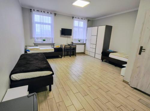 a room with two beds and a desk in it at Pałac pod Bocianim Gniazdem in Runowo