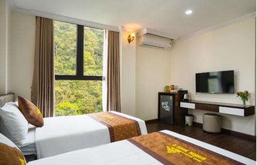 a hotel room with two beds and a flat screen tv at Khách sạn Tây Bắc Tam Đảo in Tam Ðảo