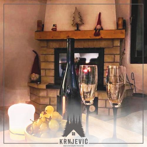 a table with two wine glasses and a fireplace at Vila Krnjević Jastrebac in Buci