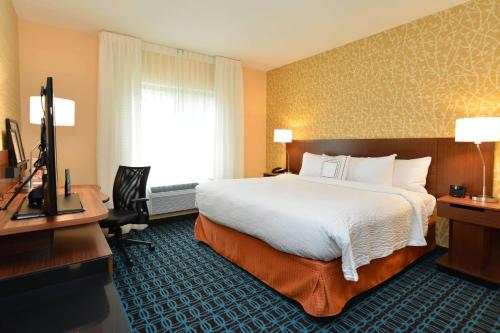 a hotel room with a large bed and a desk at Fairfield Inn & Suites by Marriott Eau Claire/Chippewa Falls in Eau Claire