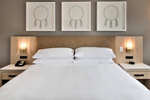 a bedroom with a large bed with two pictures on the wall at Delta Hotels by Marriott Kamloops in Kamloops