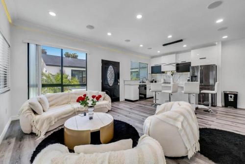 a large living room with white furniture and a kitchen at Luxury 2 bedroom villa in Huntington Beach