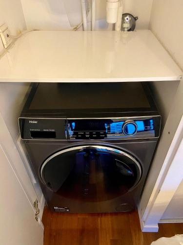 un lave-vaisselle noir dans une cuisine sous un comptoir dans l'établissement Appartement Passy PARIS, à Paris