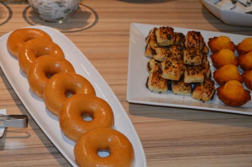 two plates of food on a table with donuts and sushi at Hotel 3K Barcelona in Lisbon