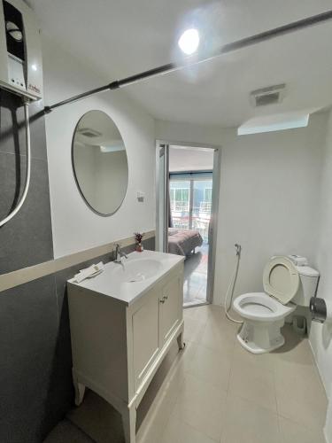 a bathroom with a sink and a toilet with a mirror at Ocean Blue Huahin Guesthouse in Hua Hin