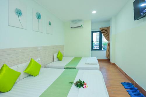 two beds in a room with green and white at My Hotel Quy Nhơn in Quy Nhon