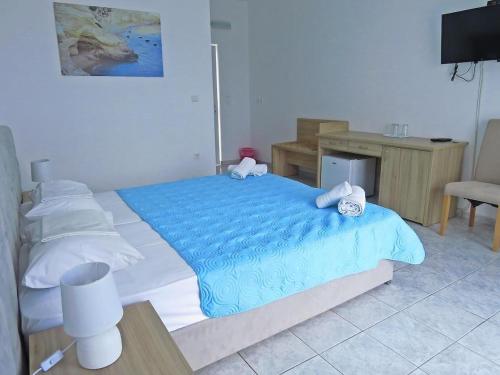 a bedroom with a blue bed and a desk at Kiotari Coast Seaside in Kiotari