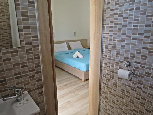 a bathroom with a bed and a shower with a sink at Kiotari Coast Seaside in Kiotari