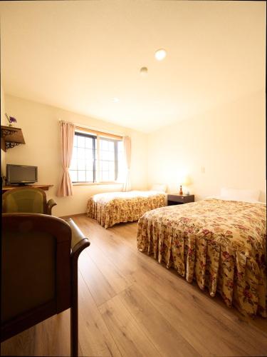 a hotel room with two beds and a window at カナリアンホテル in Tateshina