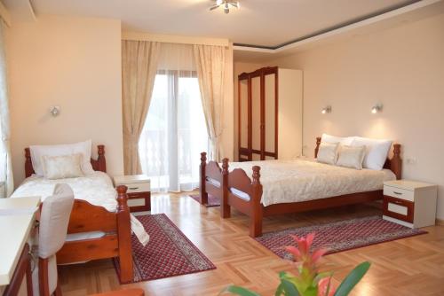 um quarto com 2 camas e uma grande janela em IN Hotel Zlatar ex Zlatarski Biseri em Nova Varoš