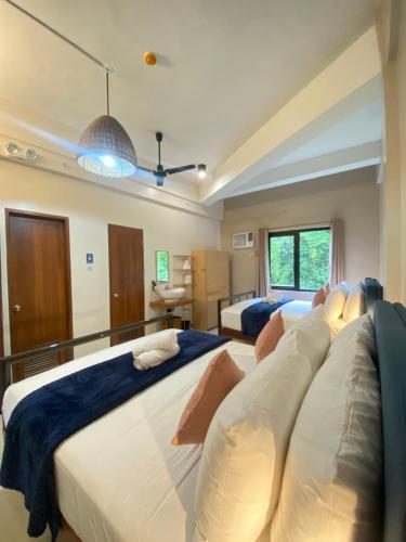 a bedroom with two beds and a window at Barco El Nido Hotel in El Nido