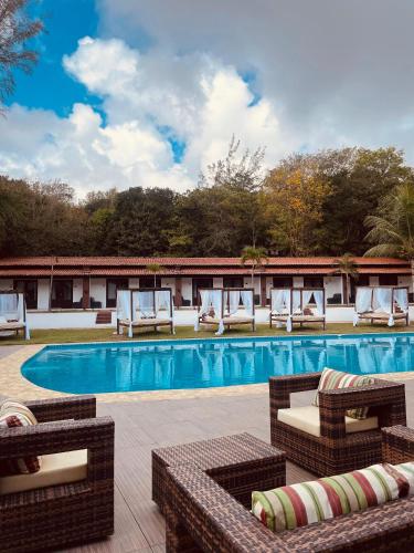 a swimming pool with lounge chairs and a resort at Verde Mar Pipa Beach in Pipa