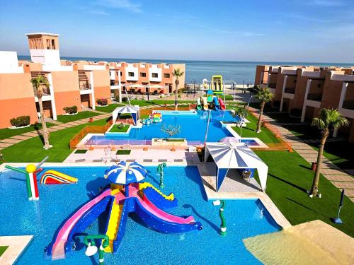 a large pool with a water park with a water slide at Aquamarine Kuwait Resort(Families Only) in Al Nuwaiseeb