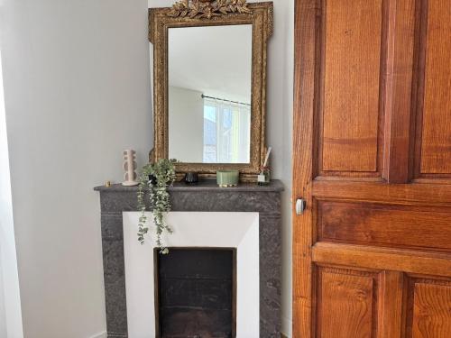 a mirror on top of a fireplace next to a door at LOustal d Henri 3 chambres in Luc