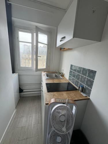 Il comprend une petite cuisine équipée d'un évier et d'un lave-vaisselle. dans l'établissement Cozy Room Nearby Champs Elysées 4, à Paris