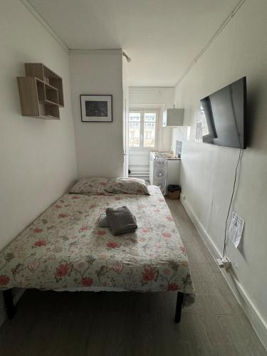 - une petite chambre avec un lit et une couverture fleurie dans l'établissement Cozy Room Nearby Champs Elysées 4, à Paris